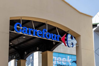 Barcelona, Spain-August 9, 2025. Entrance of a Carrefour supermarket with people entering and exiting.