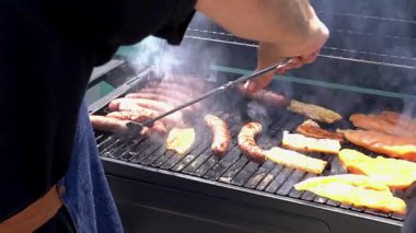 Barbeküde ızgara yapan bir adam. Arkadaşlarla boş vakit geçirmek