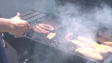 Barbeküde ızgara yapan bir adam. Arkadaşlarla boş vakit geçirmek