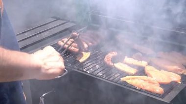 Barbeküde ızgara yapan bir adam. Arkadaşlarla boş vakit geçirmek