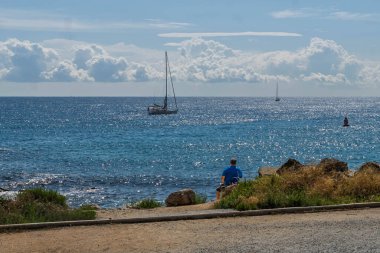 Huzurlu bir yaz gününün tadını çıkaran kişi ufka ve okyanusa bakıyor..