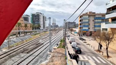 Barcelona yakınlarındaki Sant Adri de Bess 'te üç baca elektrik santrali arka planında demiryolu ve şehir manzarası var..