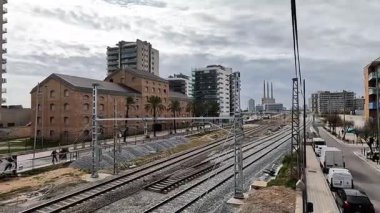 Barselona metropolitan bölgesinde demiryolu altyapısı ve tren rayları (Sant Adri de Bess / Badalona). Üç Bacalı, endüstriyel ve konut binalı şehir manzarası.