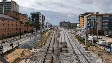 Barselona metropolitan bölgesinde demiryolu altyapısı ve tren rayları (Sant Adri de Bess / Badalona). Üç Bacalı, endüstriyel ve konut binalı şehir manzarası.