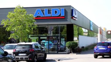 Barselona, İspanya-8 Ocak 2026. Ön planda arabaları park etmiş bir ALDI marketinin modern vitrinini gösteren geniş bir çekim..