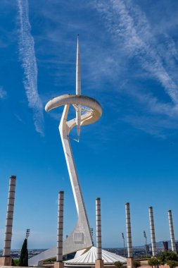 İkonik beyaz telekomünikasyon kulesi Montjuic 'teki canlı mavi gökyüzüne karşı dimdik ayakta duruyor..