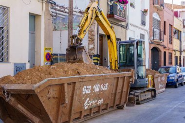Barselona, İspanya - 12 Haziran 2022. Yıkım ve apartman inşaatı sırasında kazı makinesi