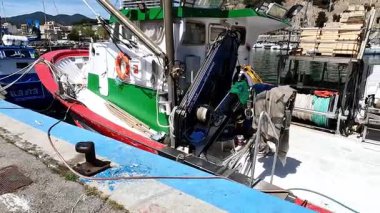 Limandaki profesyonel bir balıkçı teknesinin güvertesindeki ekipman, ağ ve vinçlerin detaylı bir görüntüsü..