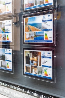 Badalona, İspanya - 3 Şubat 2026: Fiyatları, açıklamaları ve enerji verimliliği sertifikalarını gösteren bir mağaza vitrinindeki emlak reklamlarının ayrıntıları.