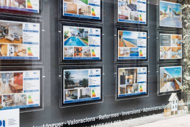 Badalona, İspanya - 3 Şubat 2026: Satılık ve kiralık dairelerin fotoğrafları, fiyatları ve enerji derecelerinin yer aldığı bir emlak acentesi.