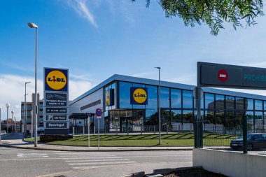 Badalona, İspanya - 22 Şubat 2026: Camdan duvarları ve park alanı olan modern bir Lidl süpermarket binasının geniş görünümü, Avrupa market trendleri ve perakende mimarisi için mükemmel.