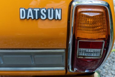 Barcelona, Spain - August 14, 2022. Datsun 180B orange color, model of the Bluebird 610 series of medium size produced between 1971 and 1976. Close-up view of the model name