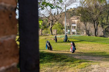 Golf arabaları ve golf sopaları golf sahasının ortasında..