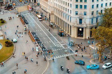 Barcelona, Spain - August 18, 2022. Top view of a street in Barcelona, Spain with car traffic and pedestrians crossing the street of office buildings.