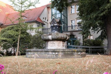 Pirna, Almanya - 3 numara. Temmuz 2025: 1989 'da Doğu Almanya' da barışçıl devrimin yapıldığı tarihi tarihi bir yerde çeşme. Siegfried-Raedel caddesinde dış bina..