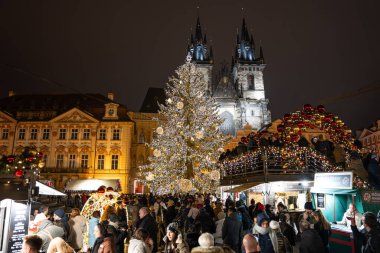 PRAG, CZECH Cumhuriyet - 14. Aralık 2025: Eski kasaba meydanında Noel pazarı (Staromestske namesti). Aydınlatılmış güzel ağaçlar ve küçük evler. Bir sürü turistin olduğu kalabalık bir yer..