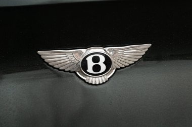 Kötü bir reçete, Almanya - 16. - 16. Ocak 2025: İngiliz lüks araba tasarımcısı ve üreticisinin Bentley logosu. Koyu yeşil bir aracın amblemini kapat. Geleneksel yüksek kaliteli ürün.