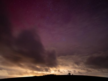 11 'deki Aurora Borealis yüzünden parlayan kırmızı gökyüzü. Ekim 2024, Almanya. Dramatik gökyüzü ve aşağıdaki şehrin yansıtıcı ışığı. Saksonya 'daki bir şehrin sebep olduğu ışık kirliliği. Avrupa 'nın kuzey ışıkları.