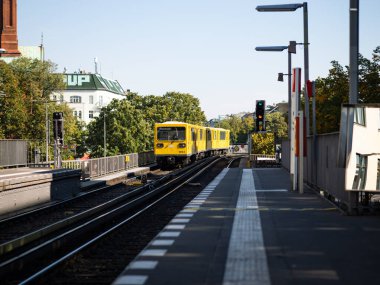 BERLİN, ALMANY - 23. Eylül 2024: U1 U-Bahn treni Gorlitzer Bahnhof istasyonuna vardı. Platforma giren rayların üzerindeki sarı metro. Kreuzberg bölgesinde toplu taşıma.