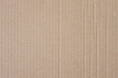 Kahverengi karton desenli arka plan. Soyut arkaplan görüntüsü olarak ambalaj malzemesi. Çizgili ve kırışık çizgileri olan boş karton deseni.