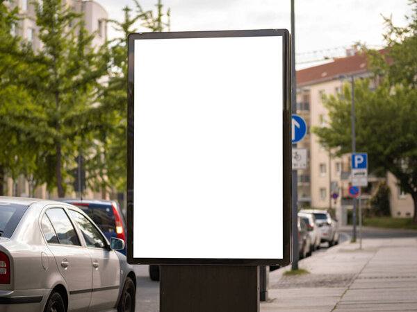 Шаблон билборда для тестирования рекламного плаката. Вертикальная ориентация плаката. Белая коробка для рекламы. Городской район Германии находится на заднем плане.