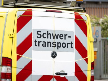 DRESDEN, ALMANY - 3. Nisan 2024: Schwertransport (ağır ulaşım) Alman dilinde bir destek aracına işaret verdi. Araba konvoyun bir parçası. Büyük endüstri parçaları ve makine parçaları nakledilecek..