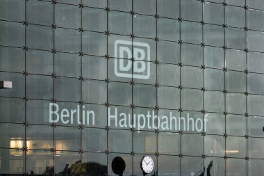 BERLİN, ALMANY - 16. Mart 2024: Binanın cam cephesinde Berlin Hauptbahnhof (merkez istasyon) tabelası. Deutsche Bahn logosu evin girişinin üstünde..