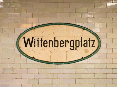 Wittenbergplatz istasyonu tabelası Berlin 'de. Toplu taşıma aracının konumu yeraltının bir parçası. Döşeme duvarı yıpranmış ve eskimiş..