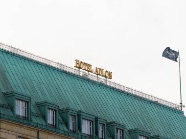 BERLİN, ALMANY - 7. Şubat 2024: Hotel Adlon Kempinski logosu Pariser Platz 'daki binanın tepesinde. Brandenburger Tor Turizm Merkezi 'nin yanındaki ünlü lüks konukseverlik hizmeti..