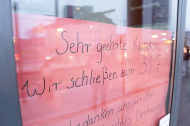 Alman dilinde giriş kapısında iş mesajını kapat. Bir mağazadan vazgeçmek. El yazısı metni: wir schliessen (işi bırakıyoruz).