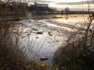 Çevredeki plastik çöp kirliliği. Bir nehir farklı tek kullanımlık konteynırları ve ambalaj parçalarını yıkadı. Almanya 'daki bir su kaynağında bariz bir çevre felaketi.