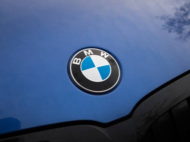 DRESDEN, ALMANY - 27. Aralık 2023: Alman otomobil üreticisinin BMW amblemi. Kaputtaki Bavyera otomotiv şirketinin logosu. Aracın dışı koyu mavi renkte..