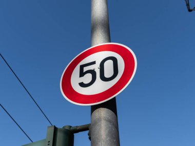 50 km / h hız limiti tabelası. Trafik levhası araba sürücülerinin saatte elli kilometreden daha hızlı gitmesini yasaklıyor. Sembol, Almanya 'nın kasabalarında, köylerinde ve iç kesimlerinde kullanılmaktadır..