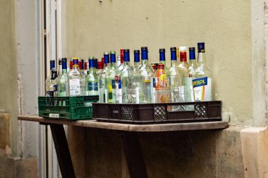 BAMBERG, Almanya - 30. Ağustos 2023: Geri dönüşüm için eski boş içki şişeleri. Etrafta duran farklı alkollü içeceklerden cam malzemeler. Bir gece partisinden sonra bardan ya da bardan gelen atıklar.