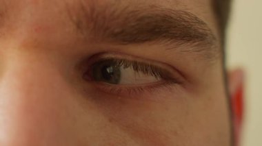 Sağına ve soluna bakıyor. Yaklaş. Bir erkeğin yüz ifadesi bu. Bir yüzün içinde gözleri sağa sola hareket ettiriyor..