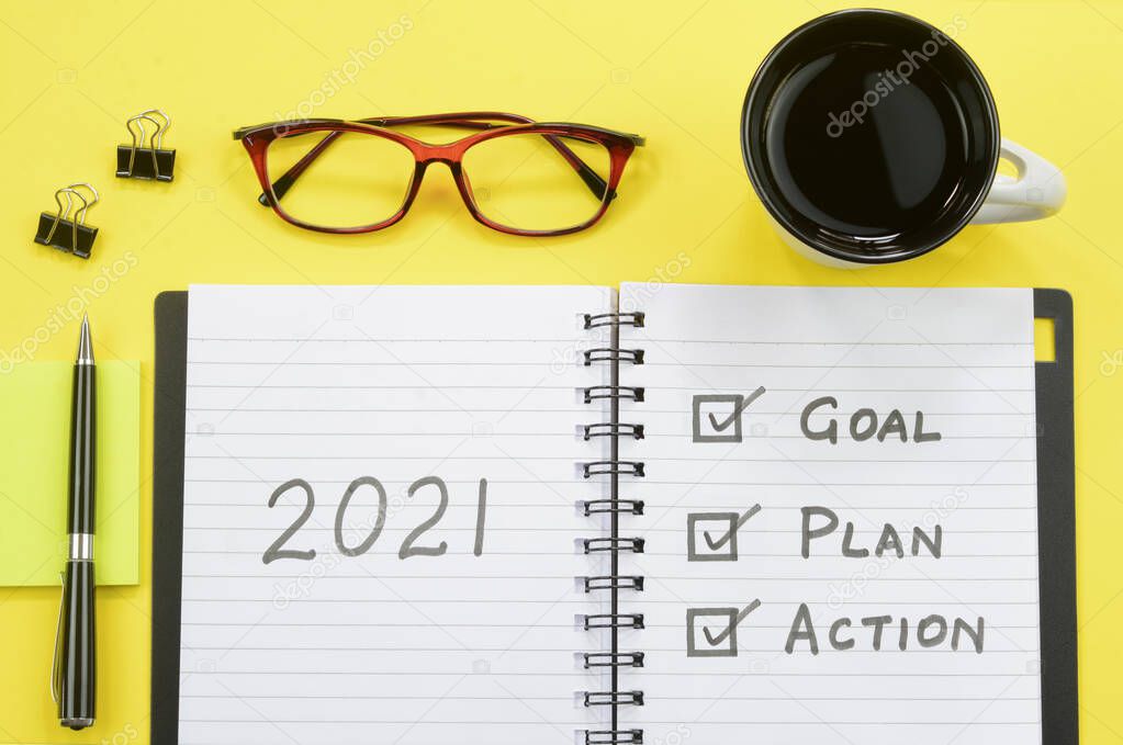 2021 goals, plan and action written on a diary