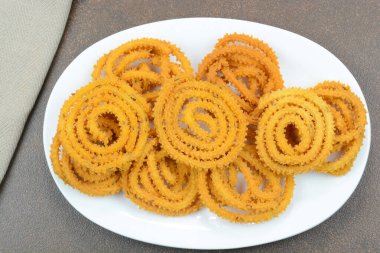 Murukku is a popular south indian savory and crunchy snack prepared during traditional festivals clipart