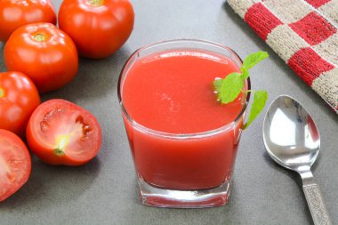 Arka planda kırmızı domatesli taze hazırlanmış domates suyu