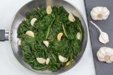 Bir tencerede sarımsaklı ıspanak tabağı