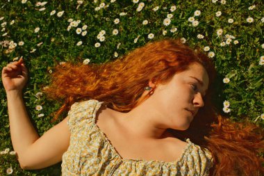 Kırmızı kıvırcık saçlı güzel kız bahar mevsiminde açık havada