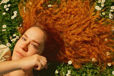 Kırmızı kıvırcık saçlı güzel kız bahar mevsiminde açık havada