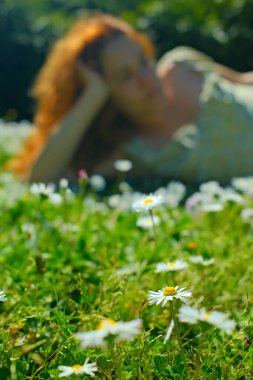 Kırmızı kıvırcık saçlı güzel kız bahar mevsiminde açık havada