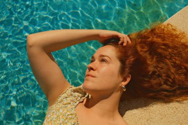 Kırmızı kıvırcık saçlı güzel kız bahar mevsiminde açık havada