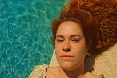 Kırmızı kıvırcık saçlı güzel kız bahar mevsiminde açık havada