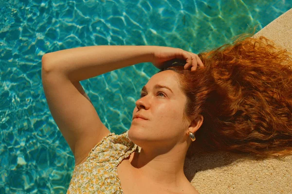 Kırmızı kıvırcık saçlı güzel kız bahar mevsiminde açık havada