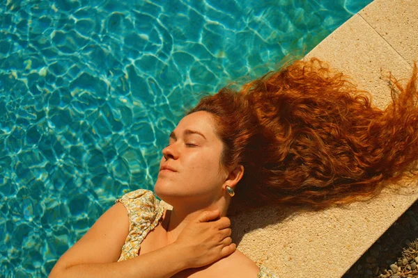 Kırmızı kıvırcık saçlı güzel kız bahar mevsiminde açık havada