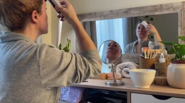 Ev Radyasyon İsteği Aygıtı ile cilt bakımı yapan kadın