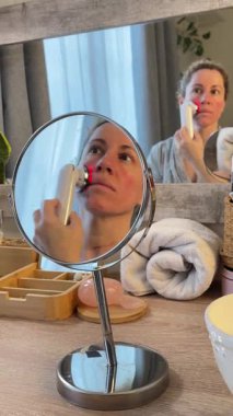 Ev Radyasyon İsteği Aygıtı ile cilt bakımı yapan kadın