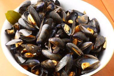 Buharda pişmiş midye, kasede sıcak servis edilir.