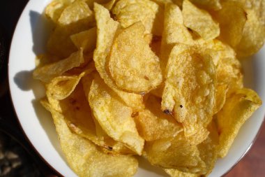 Altın patates kızartması tabakta sıcak servis ediliyor.